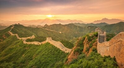Den kinesiske mur som strekker seg milevis gjennom den kinesiske landskapet.