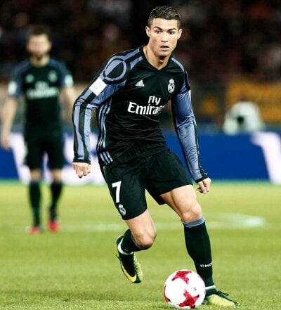 Fotballspiller Christiano Ronaldo løper med fotballen foran seg