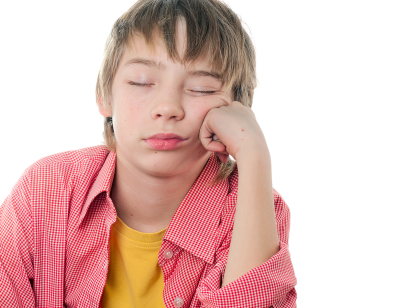 En gutt sitter og sover mens han lener hodet mot hånden. 