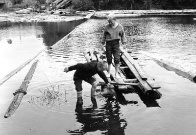 Bildet viser to gutter som leker ved Akerselva i 1962.